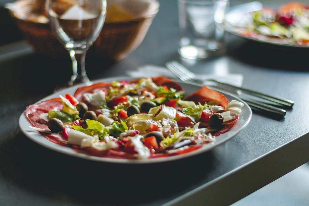 Enticing Mediterranean salad featuring olives, cheese, and fresh vegetables on a ceramic plate.